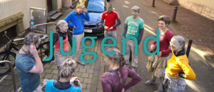 Jugendgruppe mit Farbpuder versammelt sich im Freien.